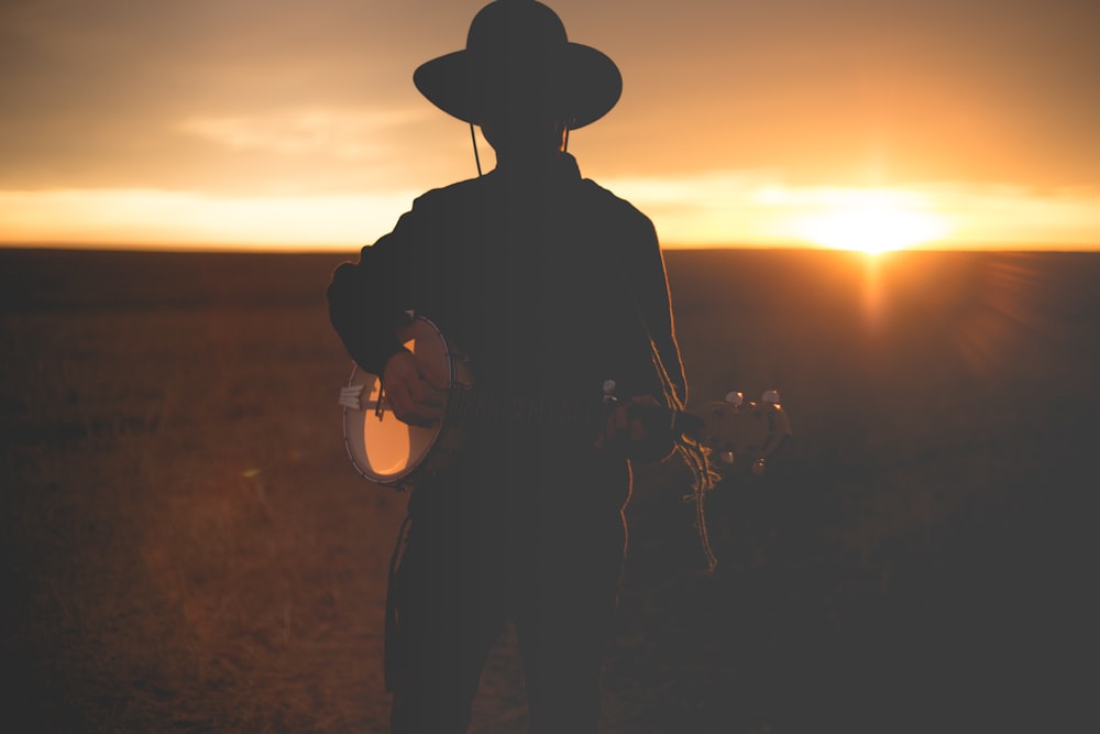 man wearing hat playing guitar