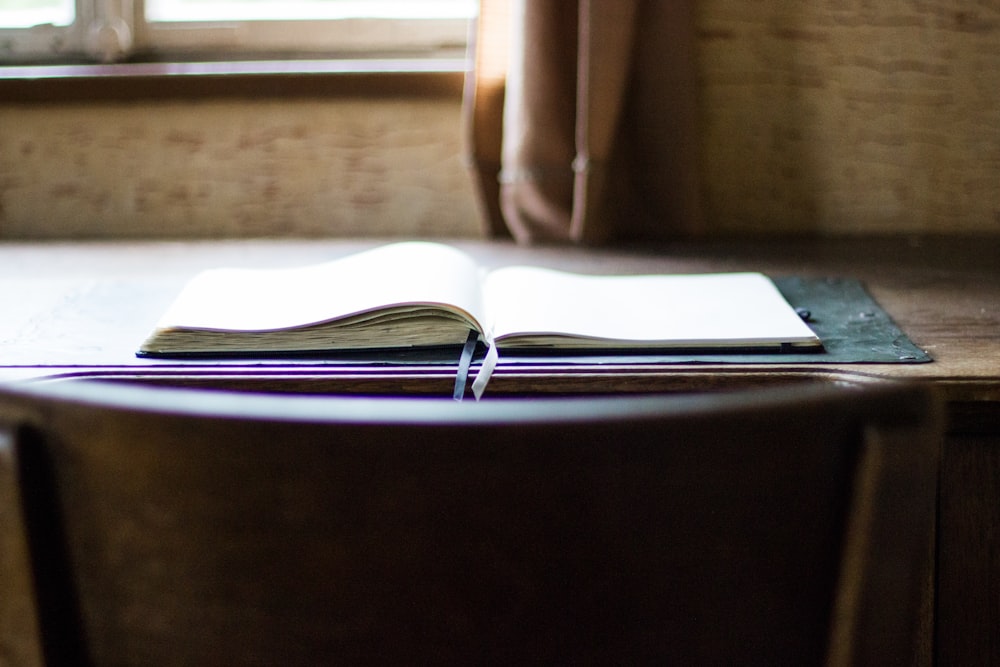 Livre ouvert sur table en bois marron