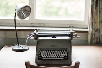 A writer's desk with a typewriter and notes in soft natural light.