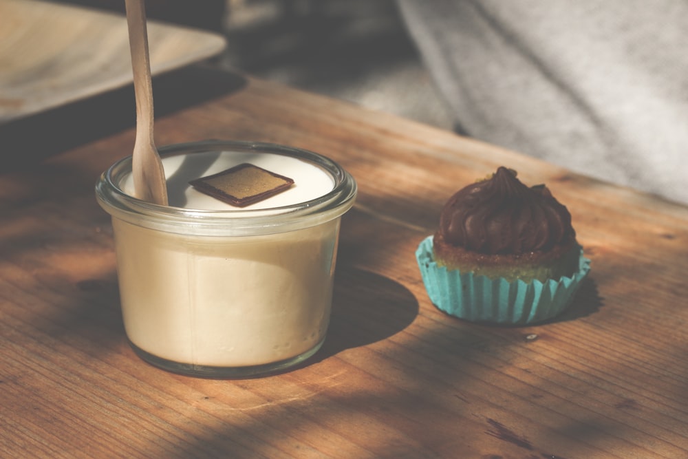 a cupcake and a glass of milk on a table