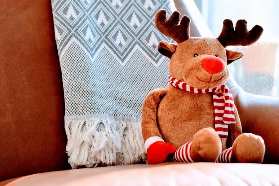 A stuffed reindeer toy with a scarf sits on a plush chair.