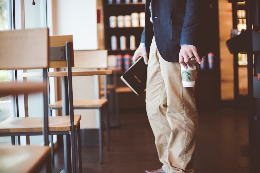 Person in a blazer and business clothes with a Starbucks coffee finding a seat