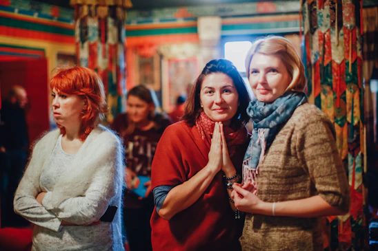 A warm gathering of women praying together in a softly lit room with gentle pastel colors.