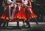 Ansambl Vila members holding hands in a circle dance under warm stage lights.
