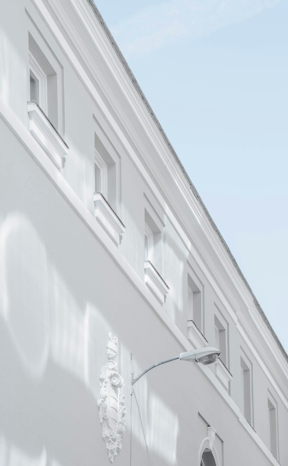 white street lamp mounted on white building wall