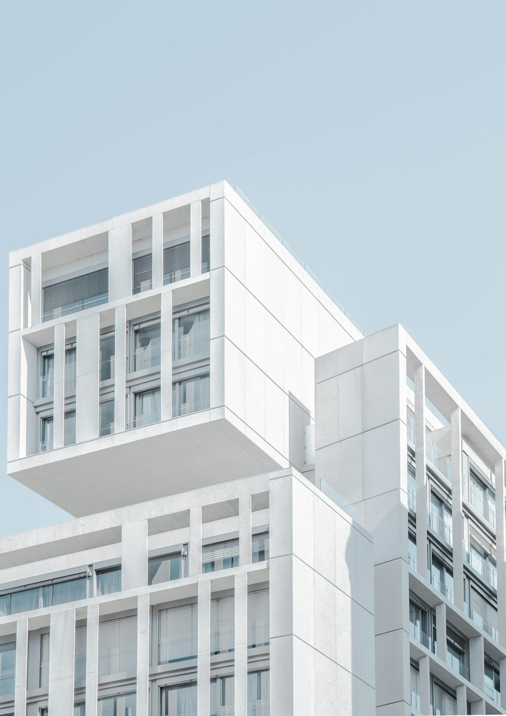 Weißes, modernes Zementgebäude unter blauem Himmel