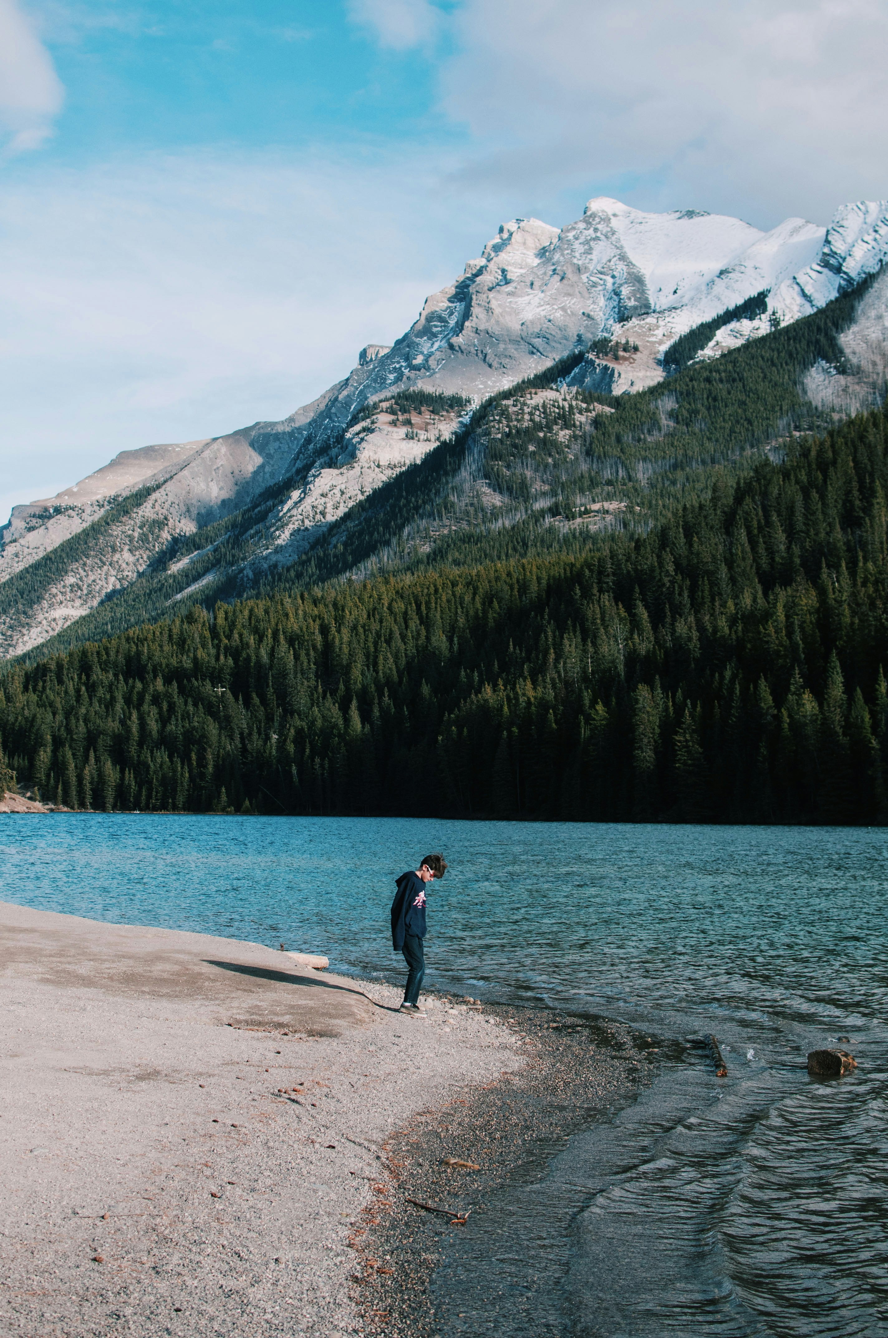 boy standing in seashore beside body of water