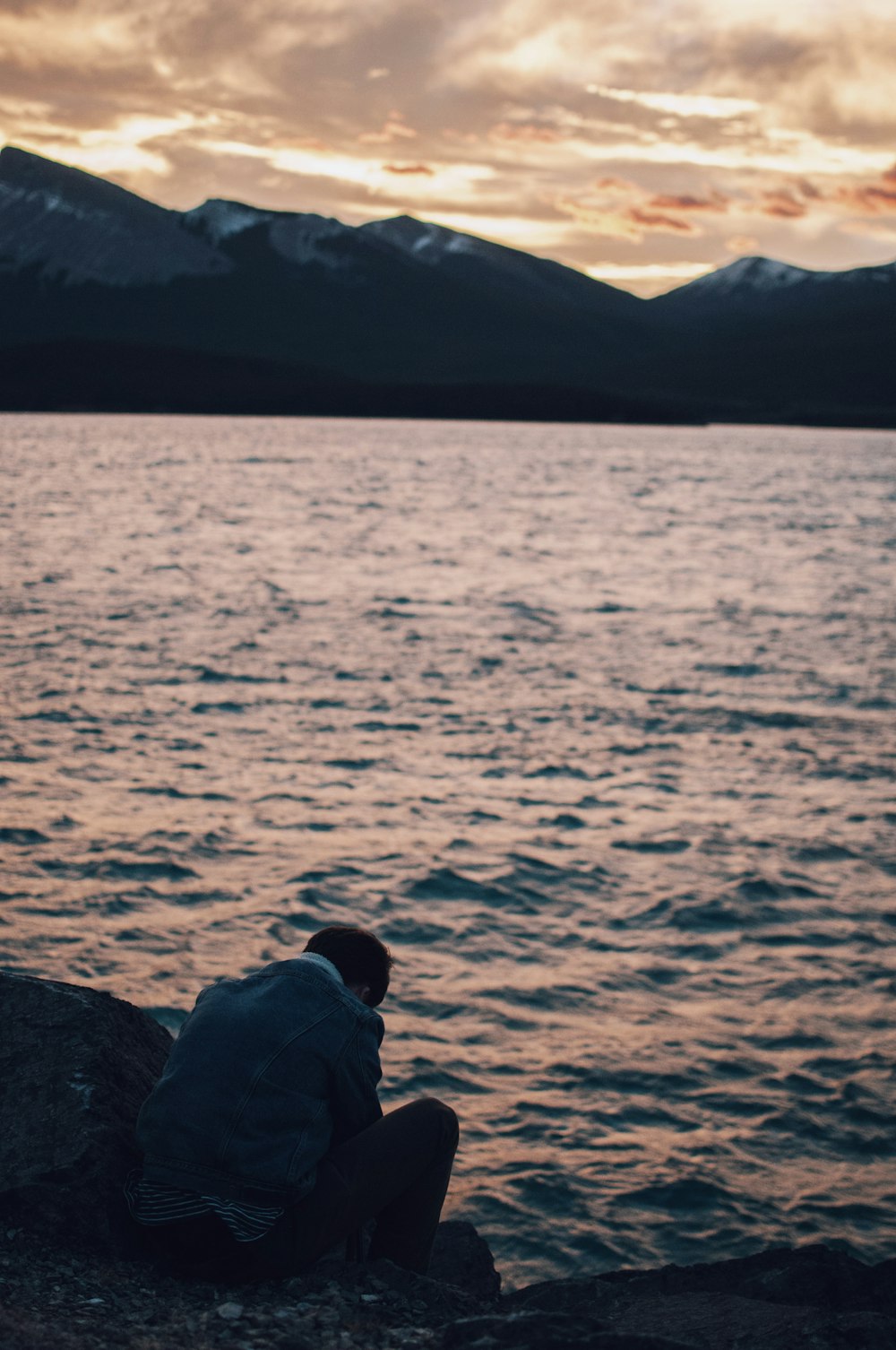 person sitting near body of water