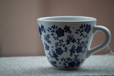 A colorful custom coffee mug featuring a bright, detailed floral design on a white background.
