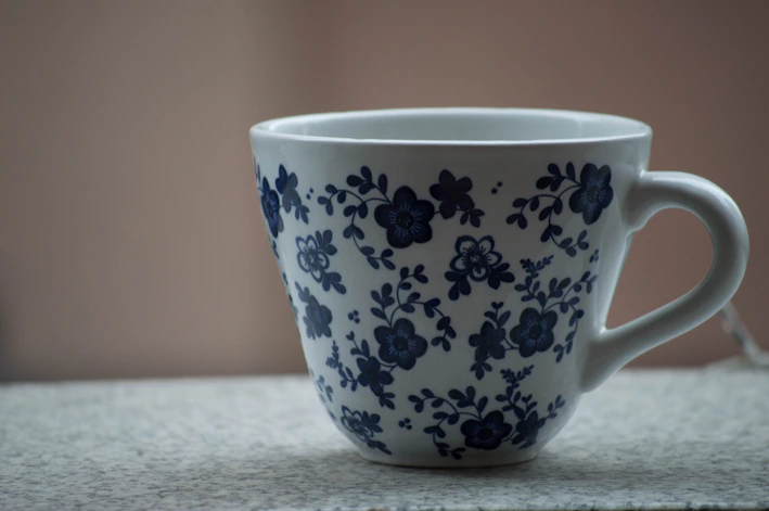 A colorful mug with a personalized name and floral design on a clean white background.