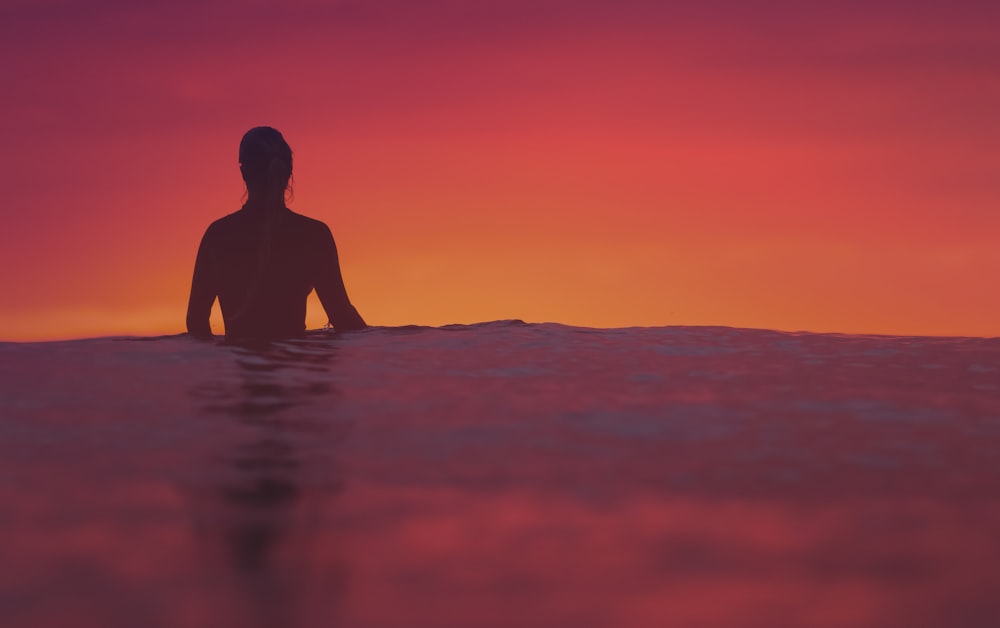 silhouette of person floating on body of water