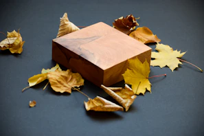 Traditional cedar urn surrounded by autumn leaves, showcasing its deep golden hues and craftsmanship