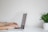 A close-up of hands typing on a laptop keyboard in a minimalist workspace.