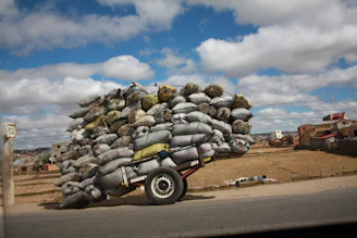 Farmers loading sacks of millet onto a truck under a clear blue sky, symbolizing trust and partnership.
