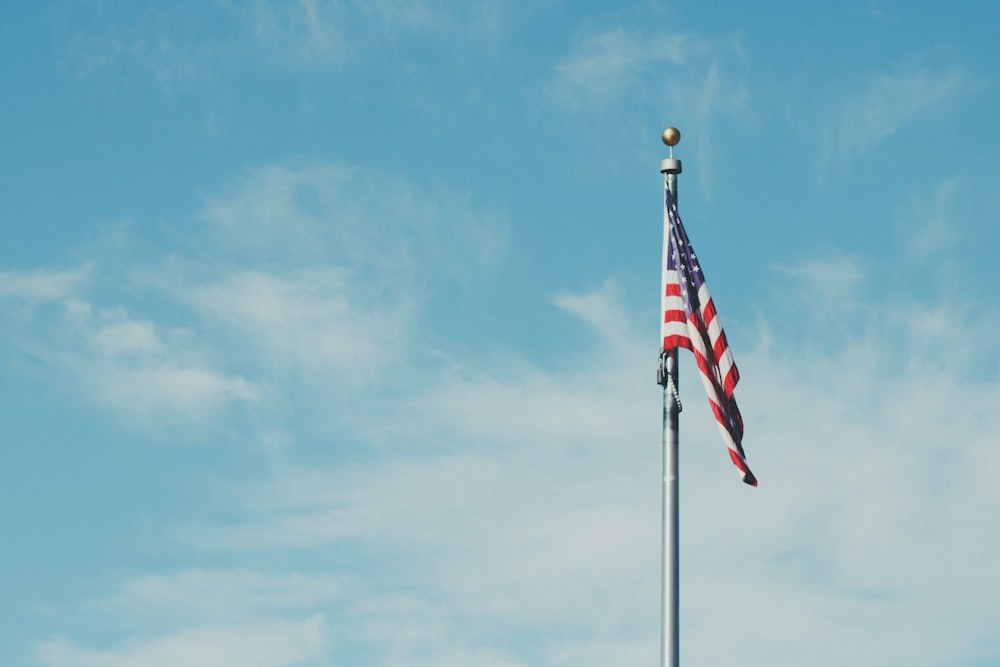 bandiera dell'America sul palo con le nuvole