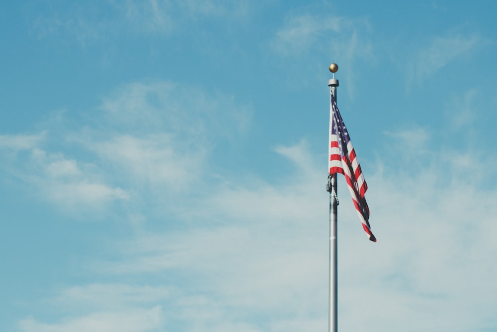 flag of America on pole with clouds