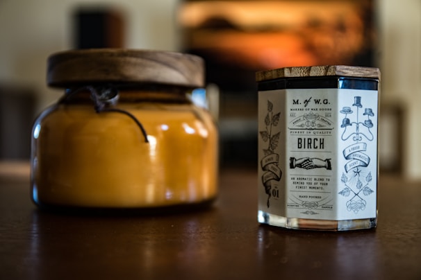 Hand-poured candles in glass jars with personalized labels, ready for gifting.