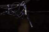 Close-up of a microphone wrapped in cables against a dark backdrop.