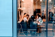 A vibrant coffee shop scene with people writing and chatting.