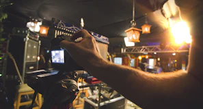 A candid moment capturing a photographer adjusting lighting in a cozy restaurant space.
