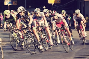 An action shot of a cyclist racing on a road during a competition.