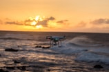 Drone flying over a beautiful coastline at sunset.