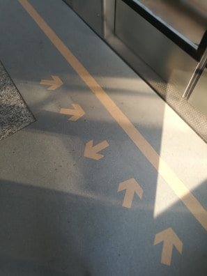 Bright yellow floor markings directing safe pathways in a busy warehouse.