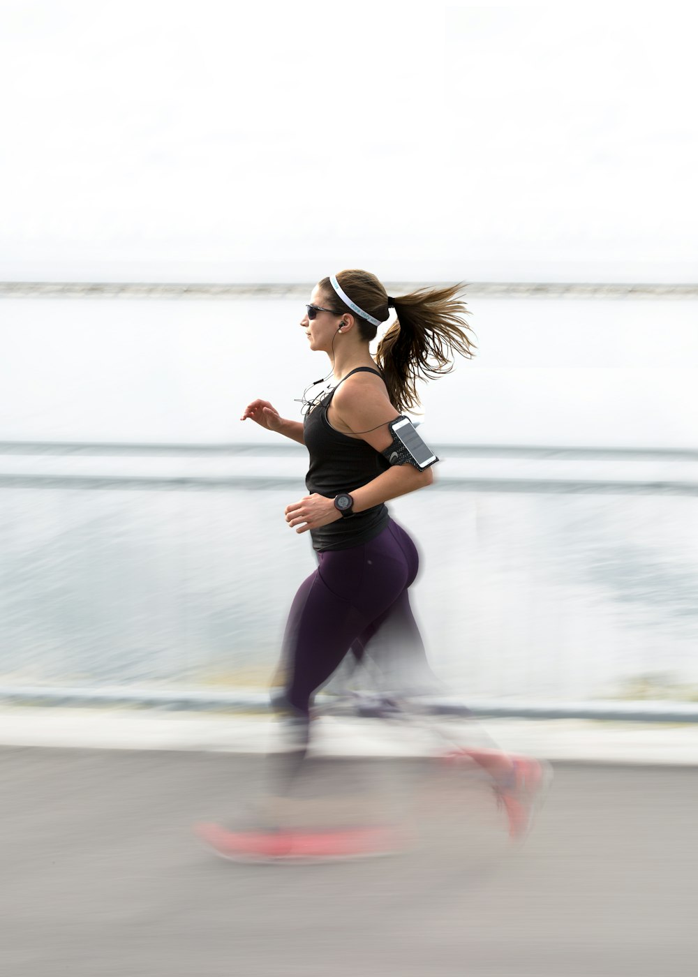 Fitness. Woman Doing Workout Exercise On Street. Beautiful Fit Girl Wearing  Fitness Tracker, Headphones And Armband Phone Case Stretching Her Long Legs  Outdoors. Sports Devices. High Resolution Stock Photo, Picture and Royalty