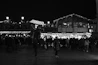 Evening shot of a lively outdoor market with string lights and crowds.