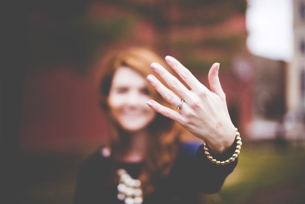 blurred photo of woman showing off her wedding ring