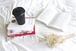 A stack of 'Crecer para Perdurar' books with notes and a cup of coffee on a modern workspace.