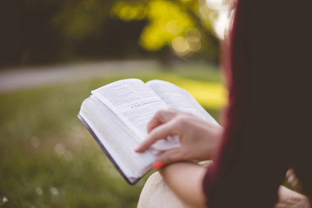 selective focus photography of person reading book