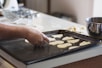 person lining assorted-shaped cookies on baking sheet inside kitchen