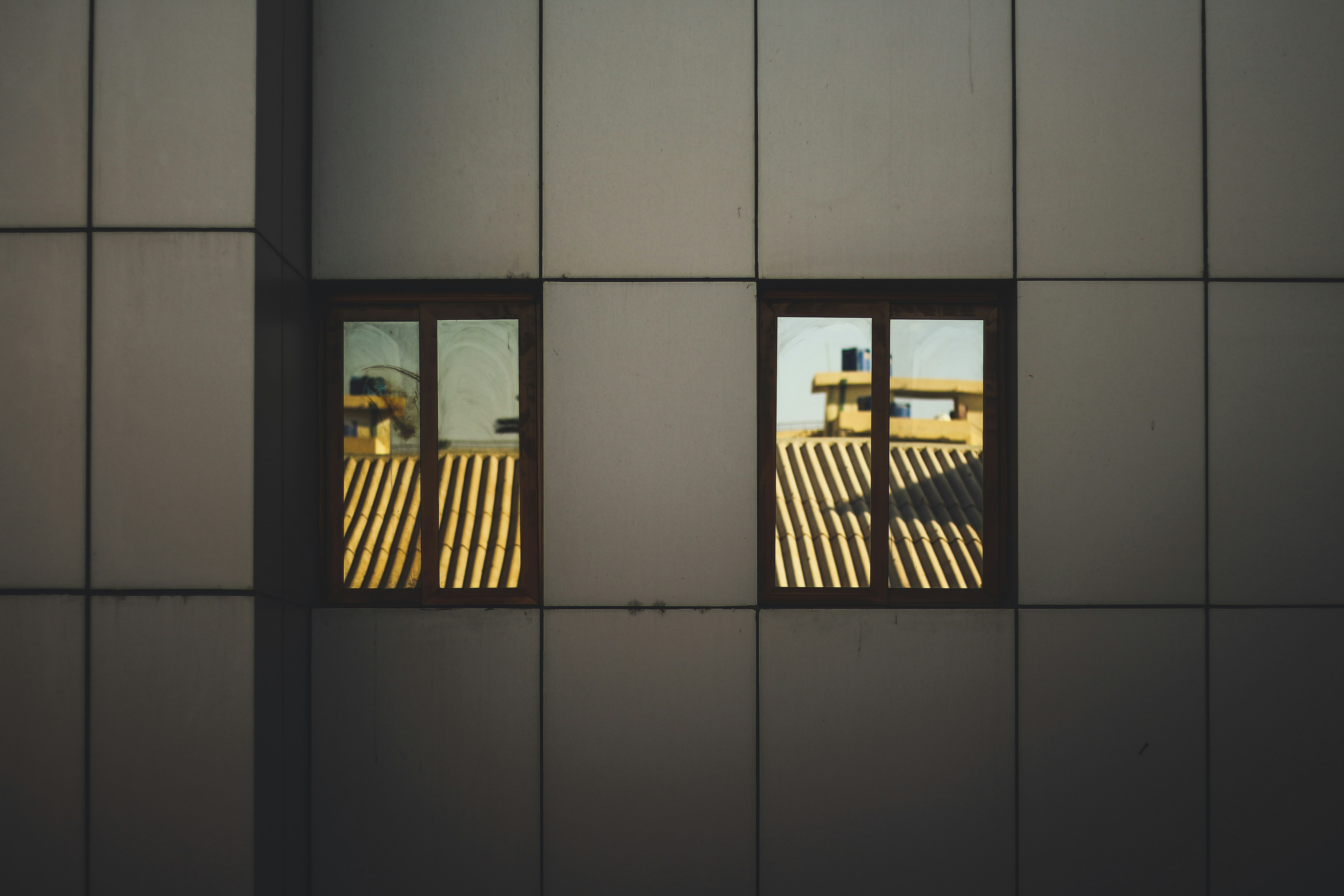 two windows viewing roofs during day