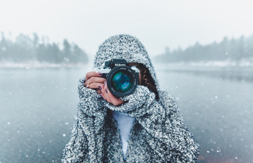 mujer usando una cámara DSLR Nikon