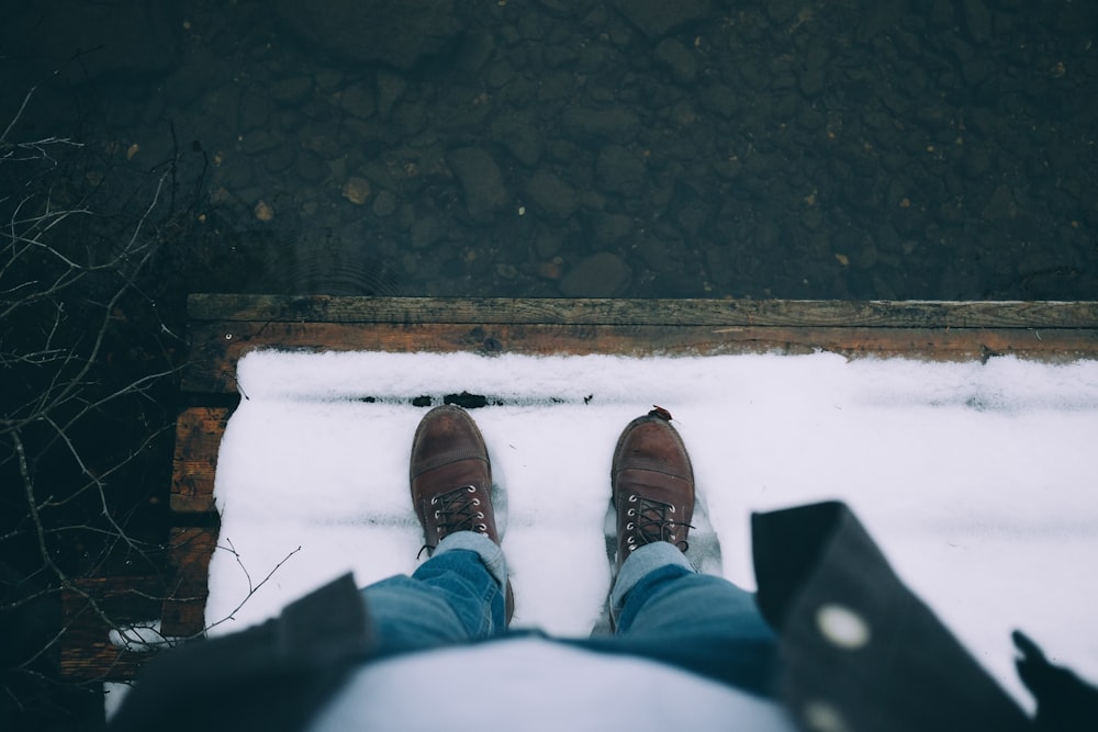 person standing on the edge of brown wooden surface