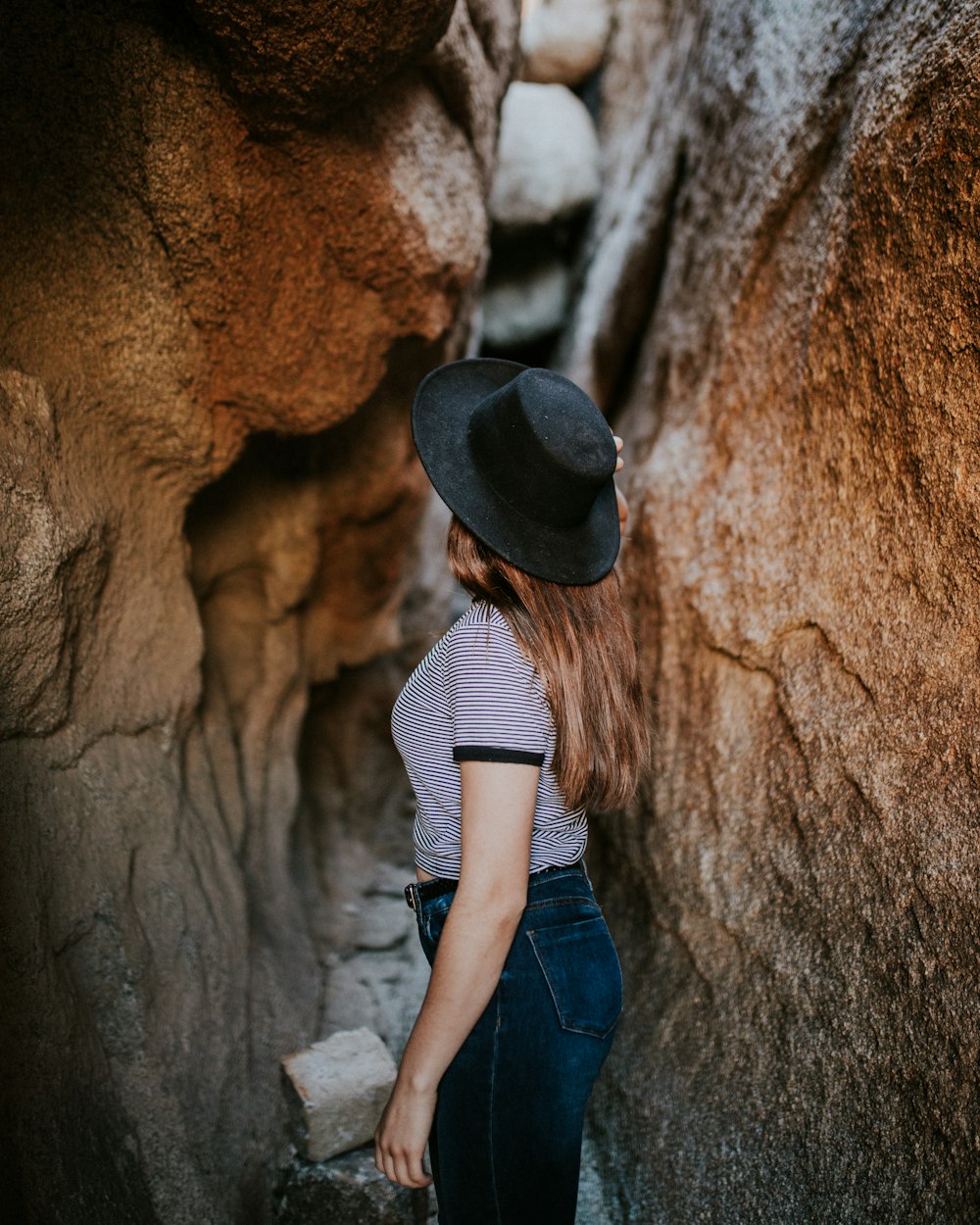 Mujer de pie entre el estrecho camino de la cueva