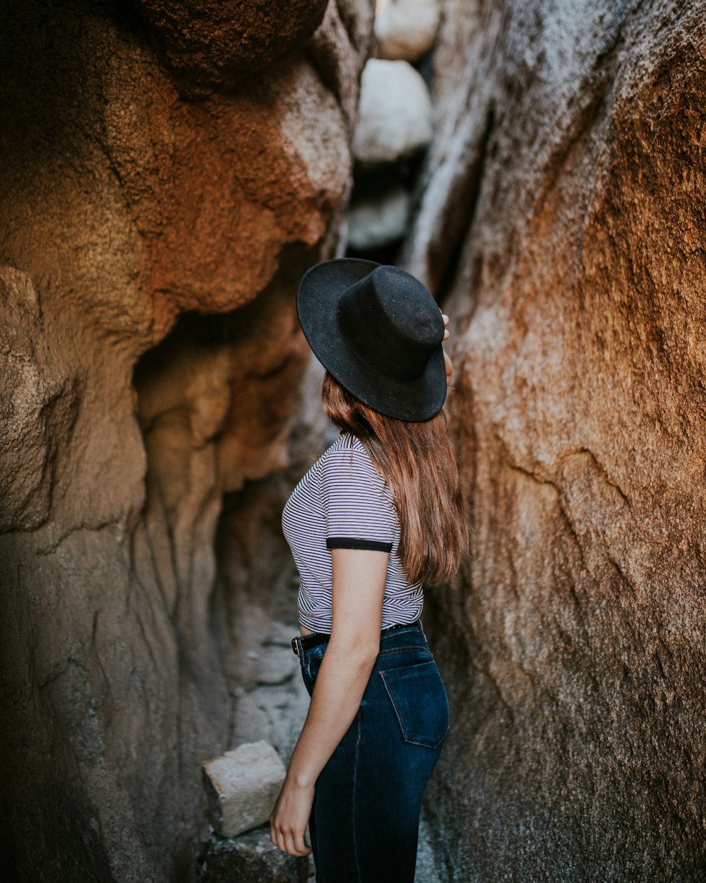 좁은 동굴 통로 사이에 서 있는 여자