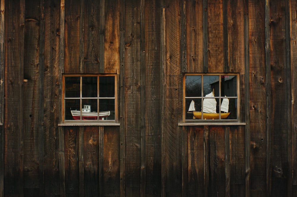 two brown sailing ship miniatures on window