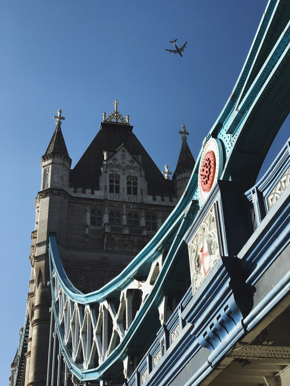 white jetliner flying over Tower Bridge