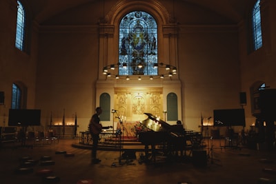 A worship leader coaching a small church team in a cozy, sunlit room filled with musical instruments.
