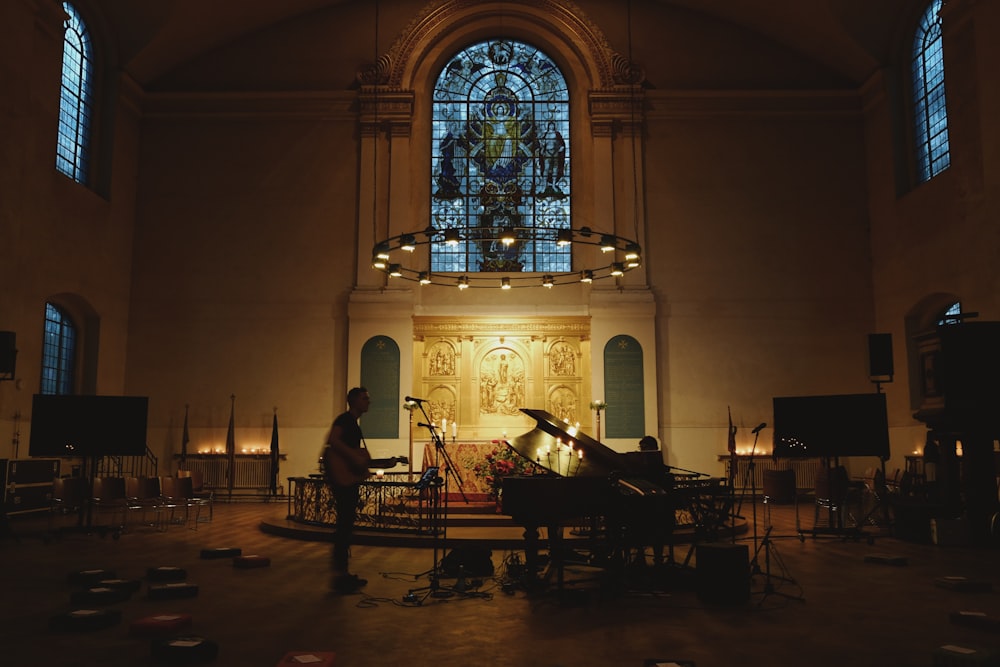 man standing holding guitar inside cathedral