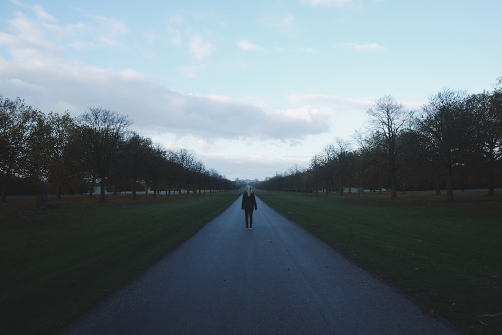 person standing on road under blue sky