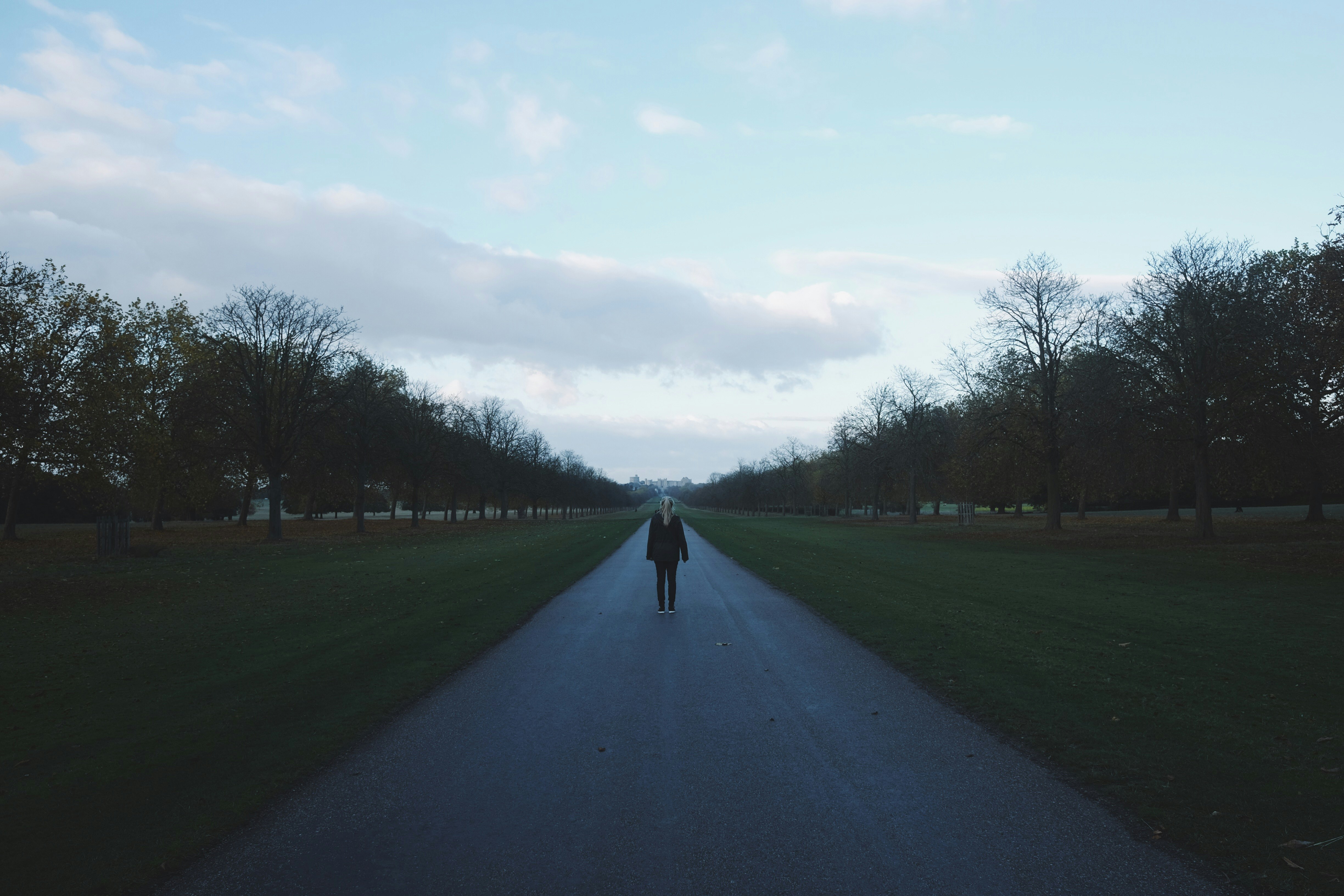 person standing on road under blue sky