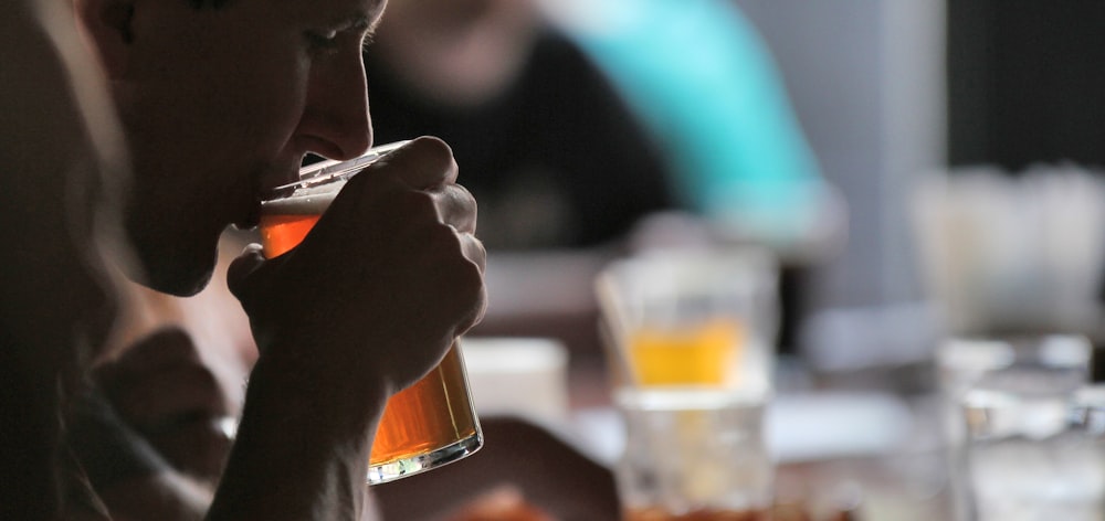 Person, die beim Trinken einen Glasbecher hält