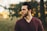 man wearing maroon V-neck t-shirt in forest