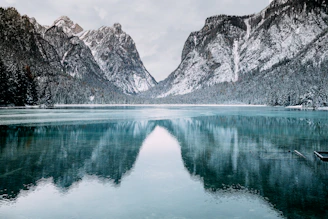 body of water and snow-covered mountains during daytime