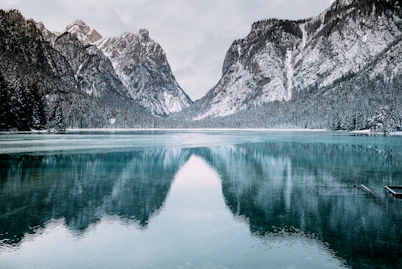 body of water and snow-covered mountains during daytime