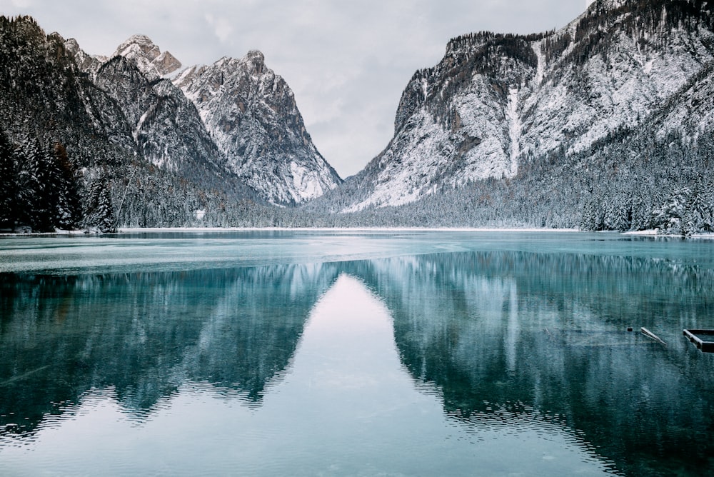 body of water and snow-covered mountains during daytime