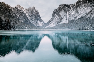 body of water and snow-covered mountains during daytime mountain google meet background